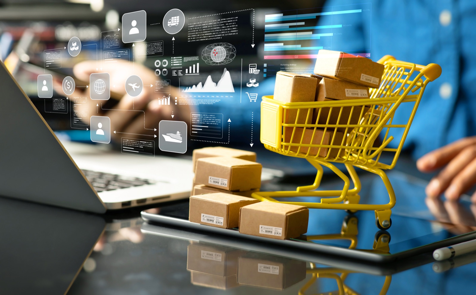 Laptop und Tablet mit eingeblendeten Grafiken zu Bestellung, Versand und Umsatz, daneben ein kleiner Einkaufswagen mit Paketen