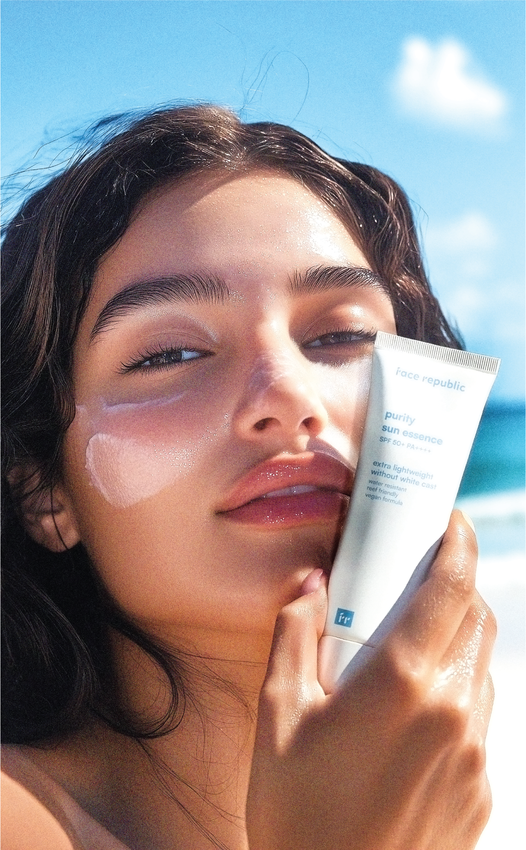 Frau mit Face Republic Purity Sun Essence vor blauem Himmel